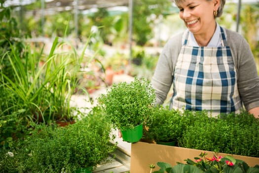 Beautiful mature woman gardening and looking at camera while smiling