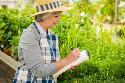 Beautiful mature woman gardening and looking at camera while smiling