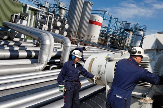 giant pipeline construction, engineer checking for leaks, two workers in foreground