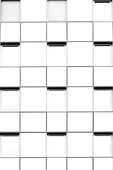 The bright white facade of a multi-storey house with symmetrically arranged windows.