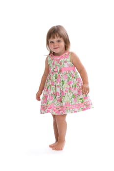 Charming little girl in a bright dress with a floral pattern. Isolate on white.