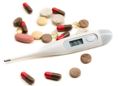 Electronic thermometer and pills isolate on white.
