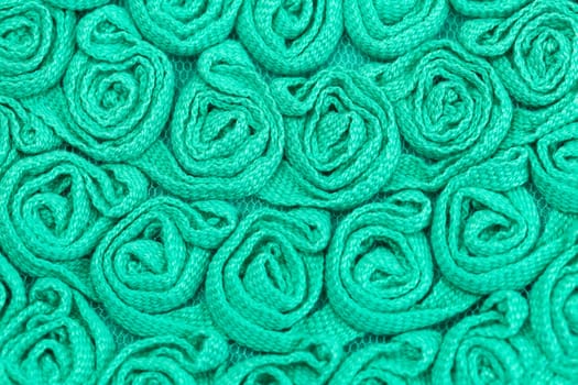 Background of green fabric in the form of bulk flowers.
