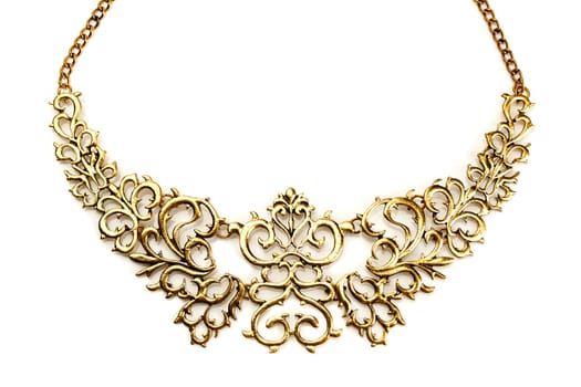 Golden necklace in the shape of tree branches on a white background mirror. Isolate.