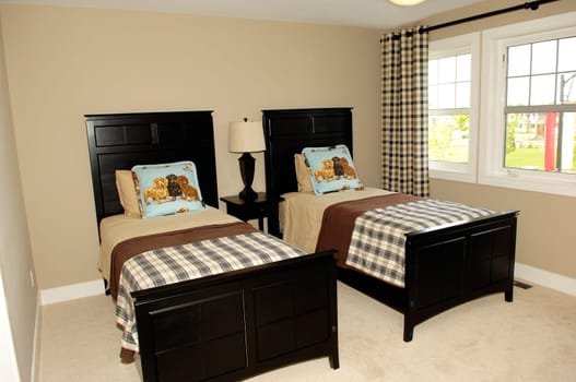 A bedroom in a new house with two single beds and large window's..