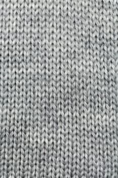 Grey knitted background of natural wool closeup.