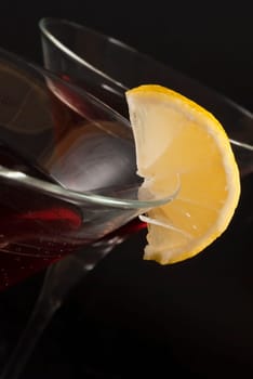 Closeup of two red cocktails with lemon slice