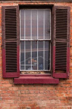 Open window shutters on an old, crumbling building.