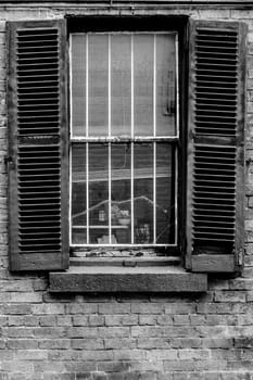 Open window shutters on an old, crumbling building.