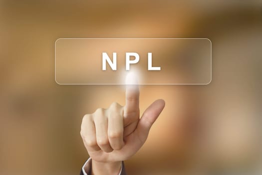business hand pushing NPL or non performing loans button on blurred background