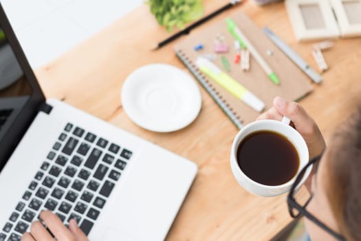 woman drink coffee and use laptop computer on desk