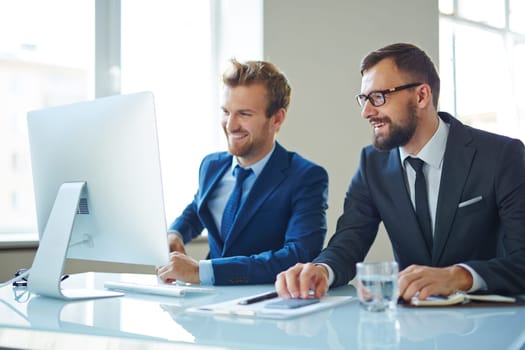 Modern businessmen consulting in front of computer at meeting