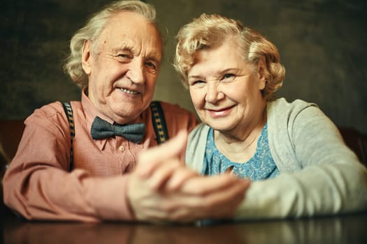 Happy retired couple looking at camera with smiles