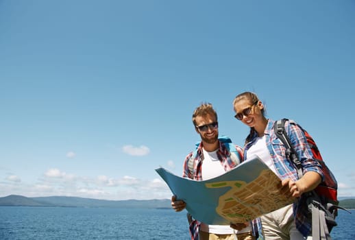 Cheerful hikers looking at guide during their trip