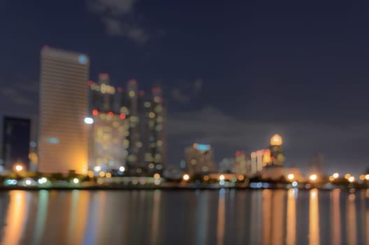 Bangkok skyline at night with reflection on water - Blurred bokeh background