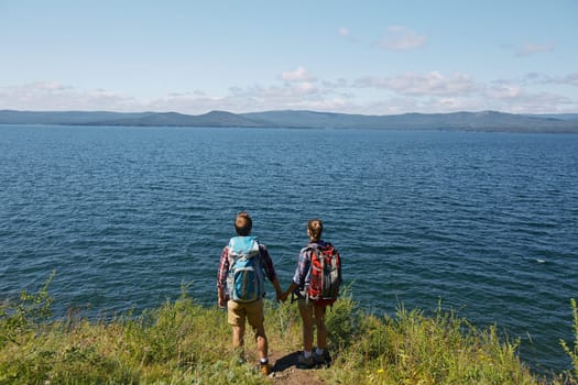 Amorous hikers admiring wonderful view of the sea