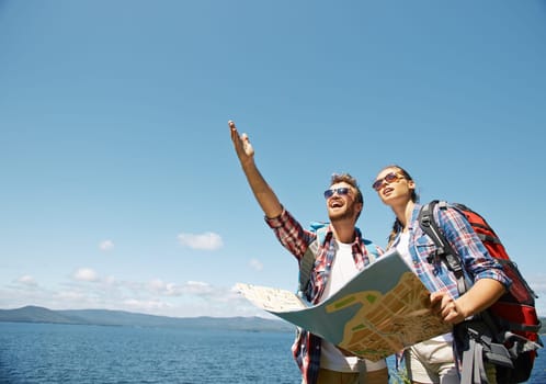 Cheerful young man showing something to his girlfriend in the sky