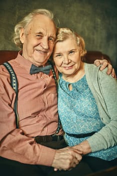 Elegant and affectionate seniors looking at camera with smiles