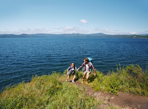 Amorous travelers hiking by the seaside in summer