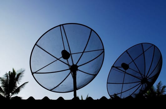 Silhouette telecommunication satelite dish with blue sky