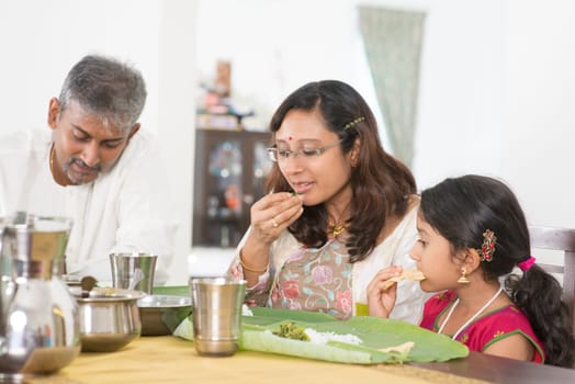 Indian family dining at home. Candid photo of India people eating rice with hands. Asian culture.
