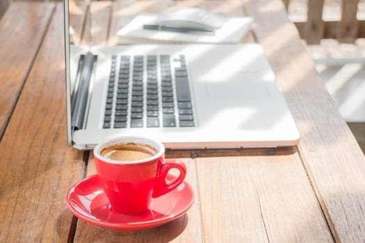 Hot coffee cup on wooden work station, stock photo