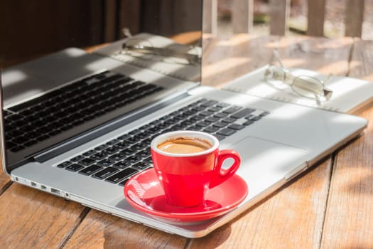 Hot coffee cup on wooden work station, stock photo