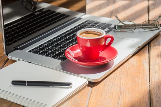 Hot coffee cup on wooden work station, stock photo