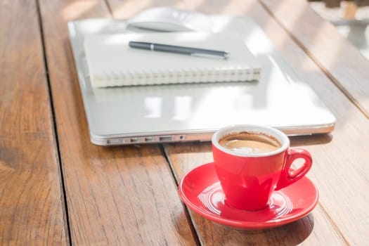 Hot coffee cup on wooden work station, stock photo