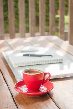 Hot coffee cup on wooden work station, stock photo