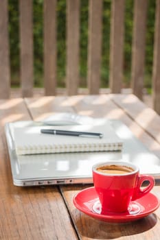 Hot coffee cup on wooden work station, stock photo