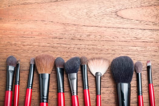 cosmetics and makeup brush, on wood table background