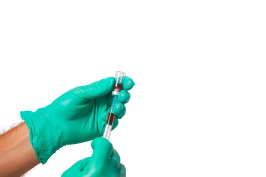 Hands of the doctors with green gloves filling a syringe