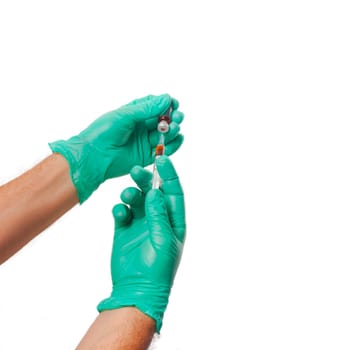 Hands of the doctors with green gloves filling a syringe