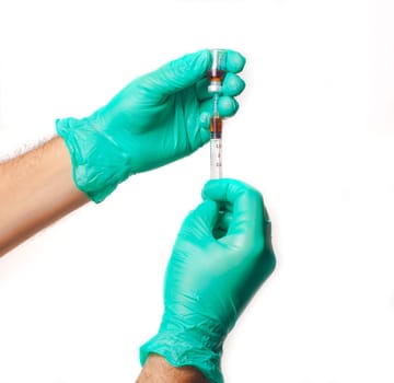 Hands of the doctors with green gloves filling a syringe