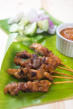 Tasty chicken sate or satay, skewered and grilled meat, served with peanut sauce. Fresh cooked with steamed and smoke. Hot and spicy Asian dish.