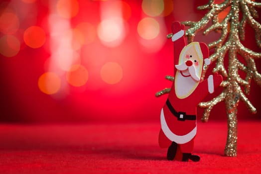 Christmas ornaments santa claus and tree with blurry glitter shiny lights at background, copy space at side.