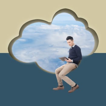 Cloud concept with man sit at a cloud shaped wall and using tablet.