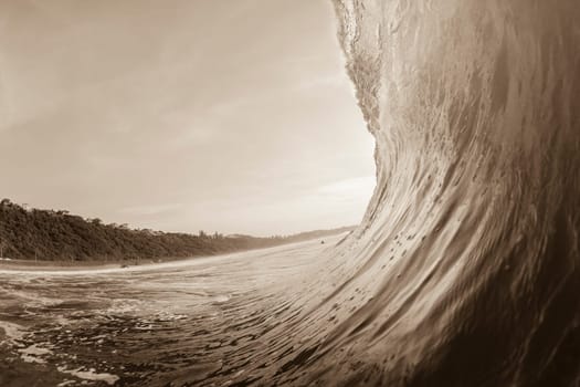 Ocean wave swimming inside crashing water power tube detail.