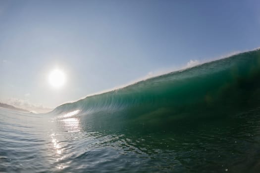 Ocean wave swimming inside crashing water power tube detail.