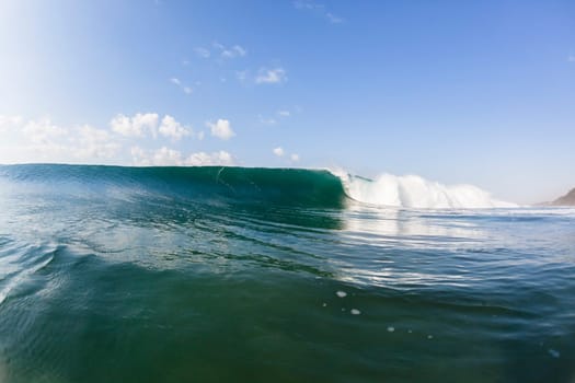 Ocean wave swimming inside crashing water power tube detail.