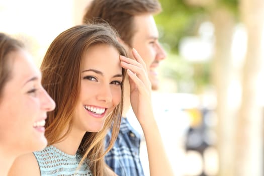 Beauty woman with white smile and teeth between friends in the street