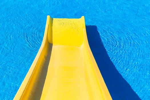 Swimming pool blue water yellow slide outdoors