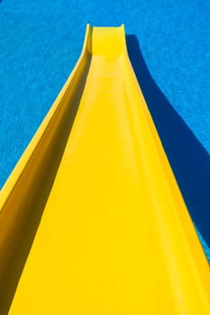 Swimming pool blue water yellow slide outdoors