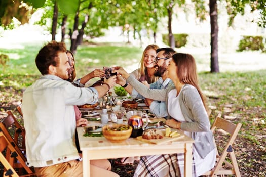 Group of young friends toasting with red wine at Thanksgiving table