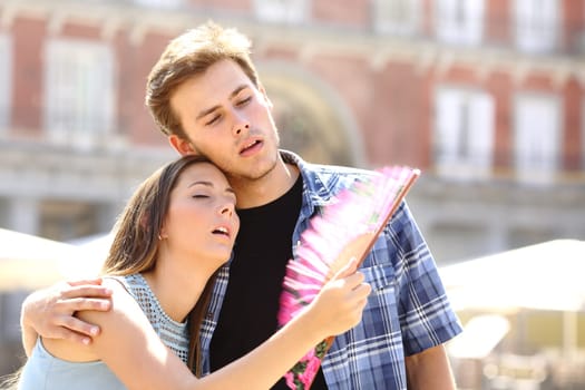 Couple suffering summer heat and fanning with a fan