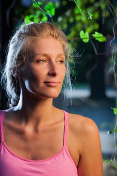 Side head portrait of a smiling middle-aged blonde woman in the side window light