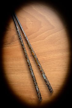 Japanese chopsticks with pearl inlays on wooden background