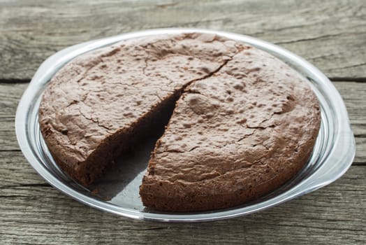 Chocolate cake in the backlight on a plate