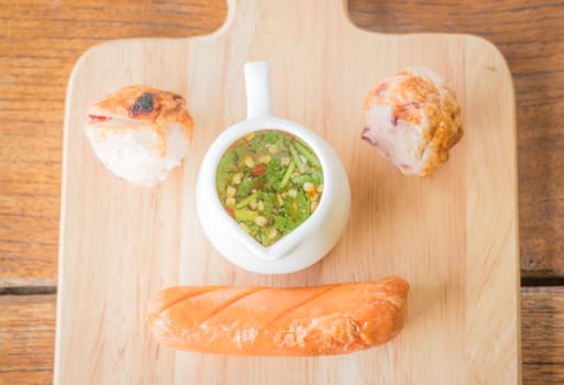 Squid ball and hotdog grilled on wooden plate, stock photo